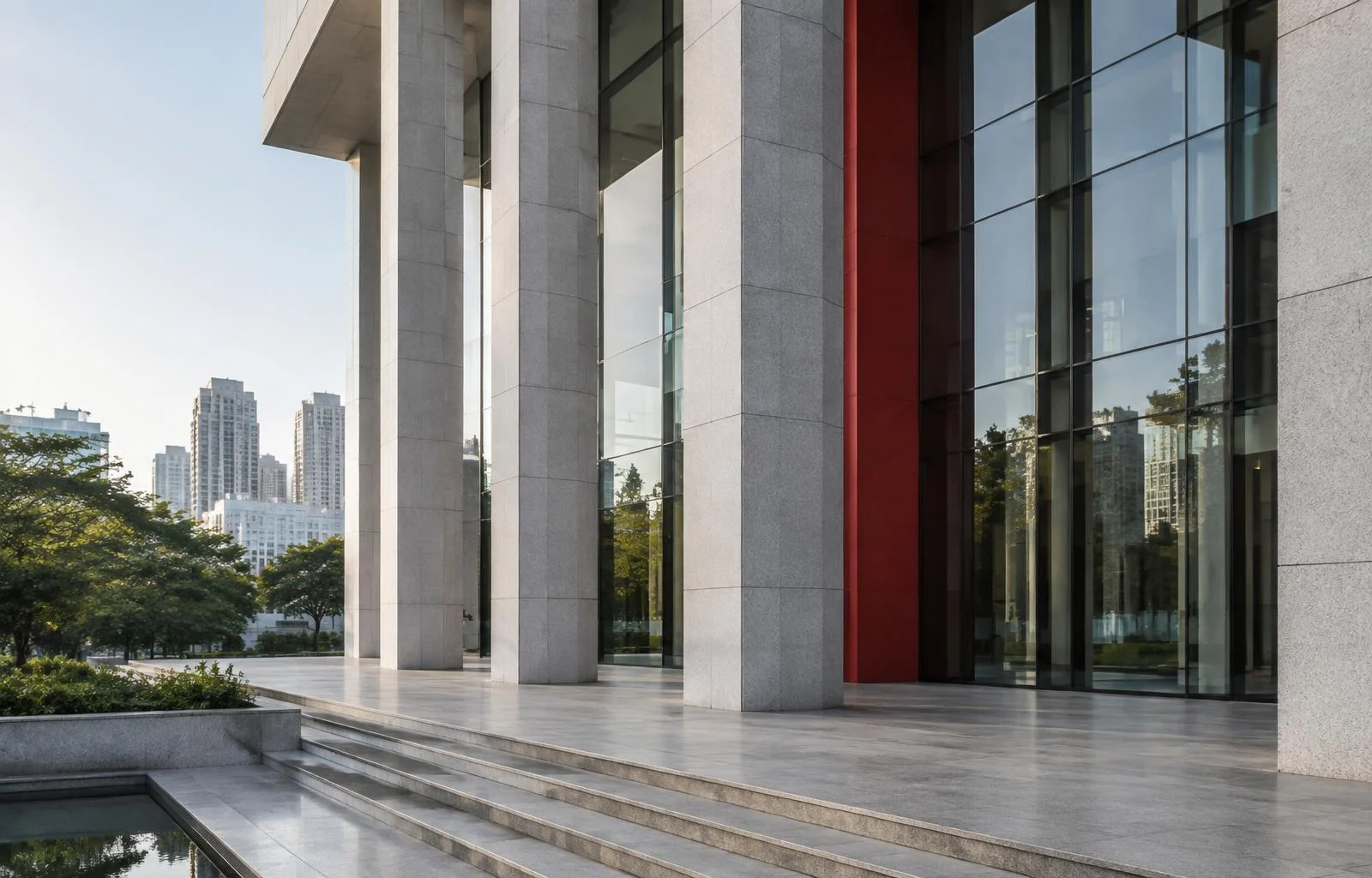 Arquitetura corporativa com colunas de pedra, fachada de vidro e detalhe vermelho